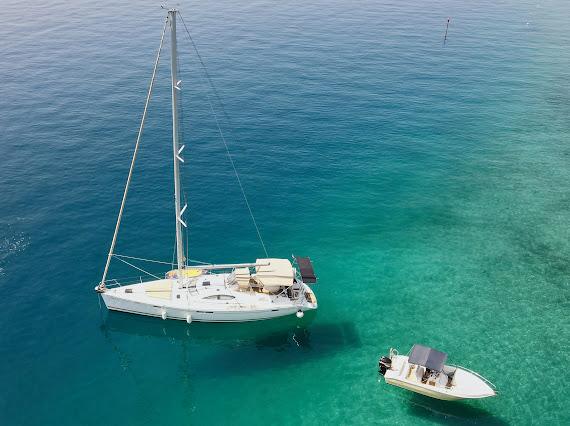 Sailboat and tender on crystal-clear turquoise sea